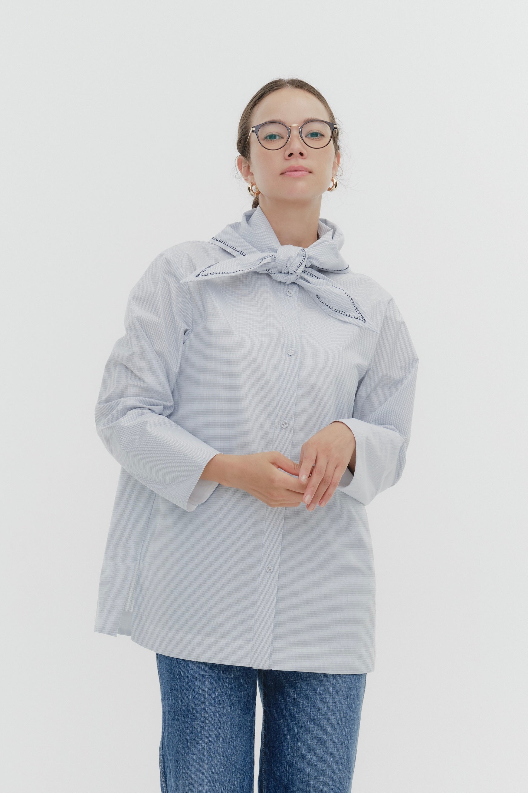 Model wearing white Sailor Ribbon Shirt with distinctive marine collar and decorative stitching details.